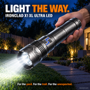 Hand holding the IRONCLAD X1 XL Ultra LED flashlight lighting a garden path at night with a bright beam