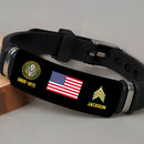 Customized U.S. Army veteran bracelet in black silicone with engraved American flag, Army emblem, service years, rank chevron and name, placed on a wooden block
