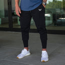 Man wearing black Performance Tech Joggers with white trainers