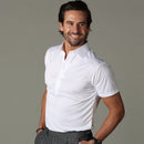 Man wearing the white polo shirt against a neutral studio background