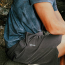 Seated person wearing charcoal Serrano stretch shorts outdoors
