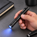 SlimBeam penlight on a desk with a blue beam