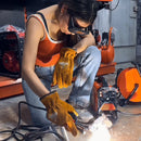 Woman welder with protective gloves and mask using compact Mini Welding Machine on workshop floor with sparks