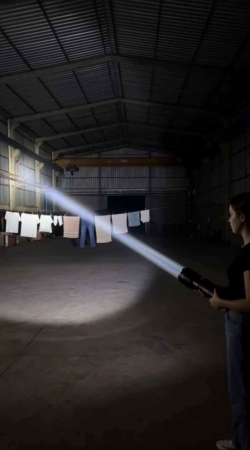 A man demonstrating a bright flashlight beam inside a large warehouse